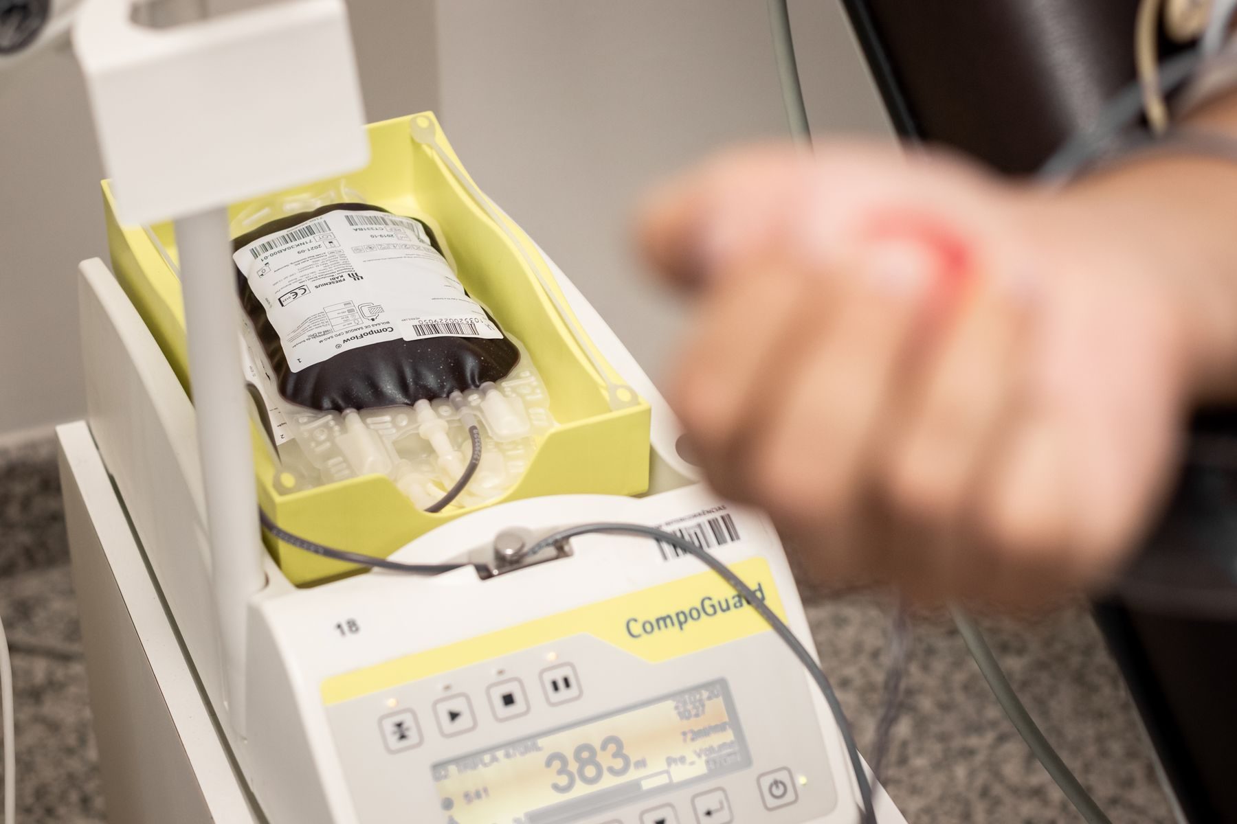 A blood bag on a blood-collection monitor showing a numeric readout.