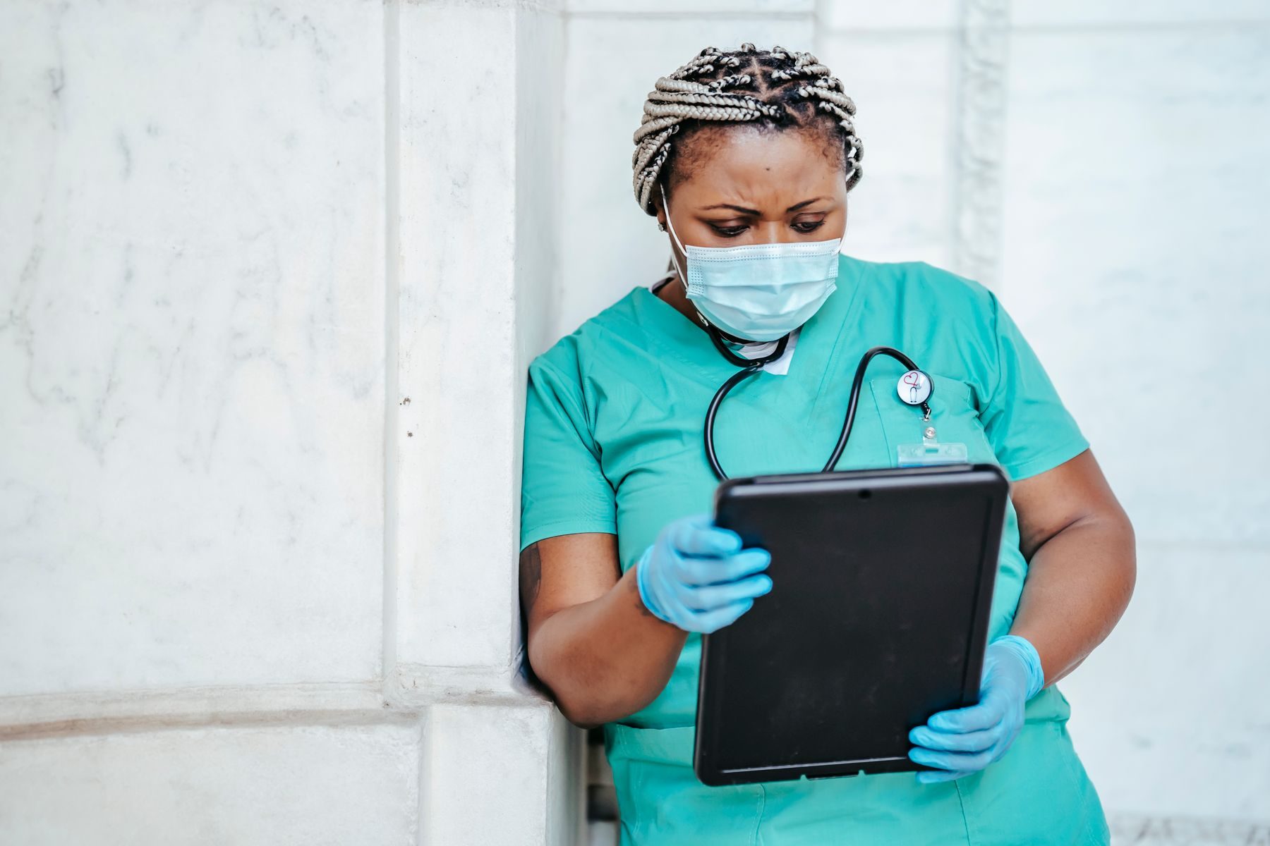 A health worker recording information on a tablet.